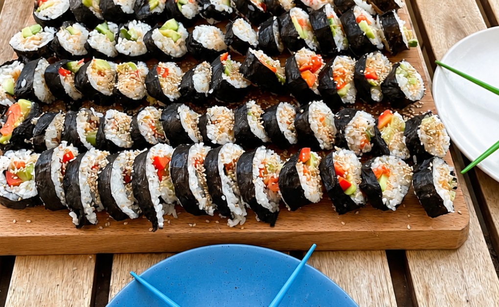 Selbst gerollte Maki-Sushi mit Lachs, Avocado und Gemüse